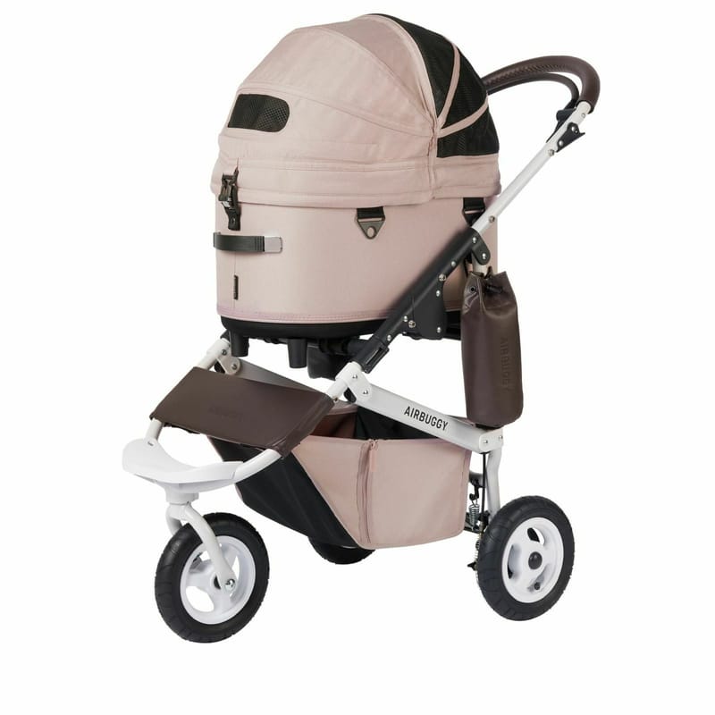 AirBuggy 粉色三輪寵物推車，附圓頂遮陽棚、底部置物籃與棕色皮革把手