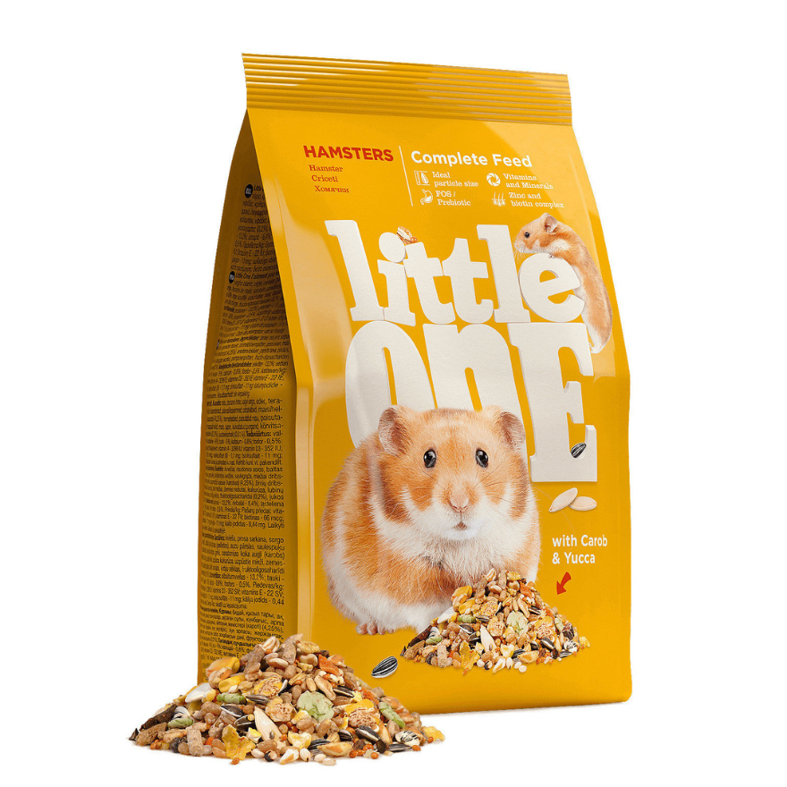 Little One 倉鼠完整飼料黃色包裝袋，印有金黃色倉鼠，袋前散落混合穀物與葵花籽